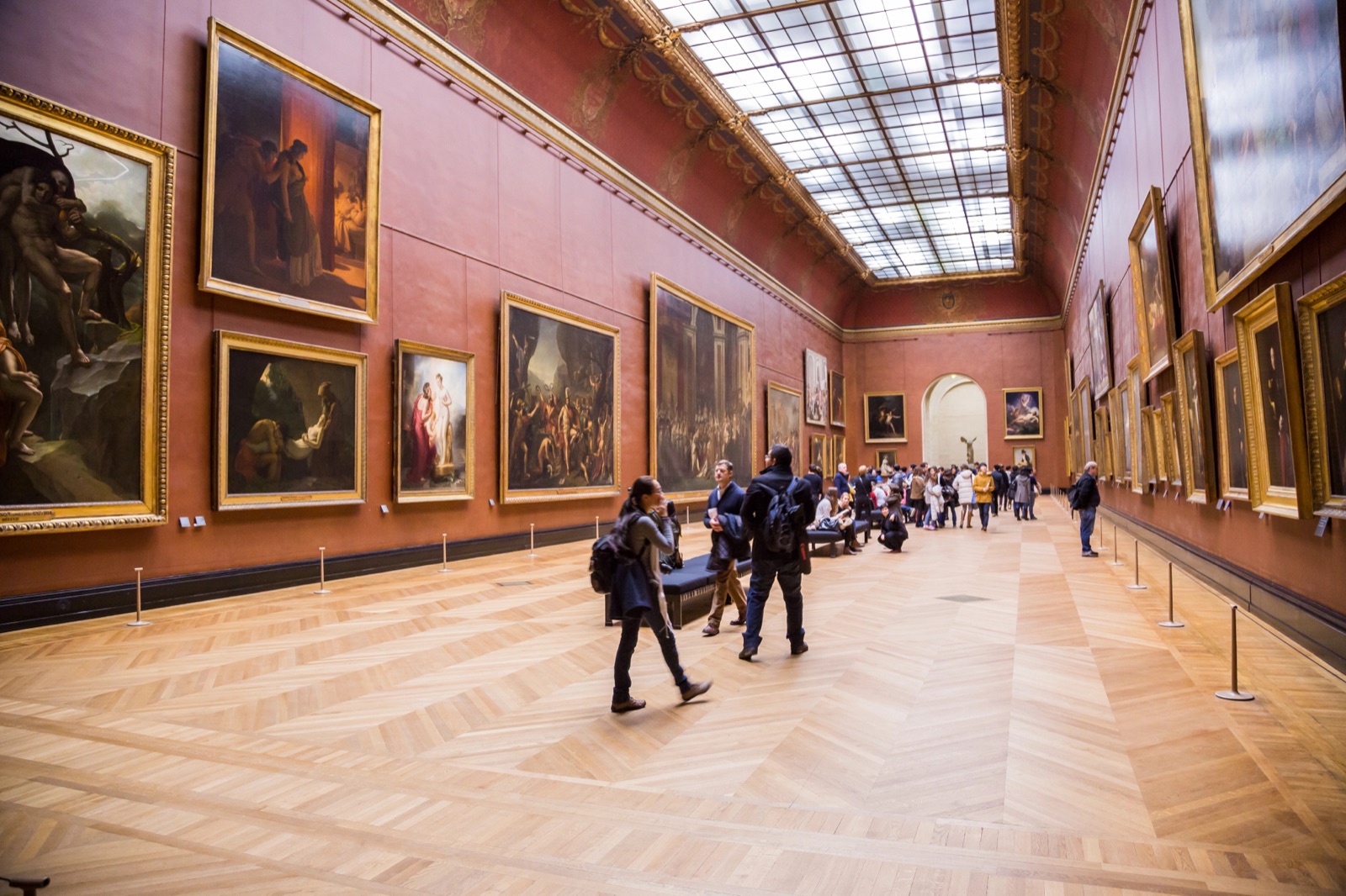 The Louvre's grand gallery of large paintings, with the Winged Victory of Samothrace framed in the far archway
